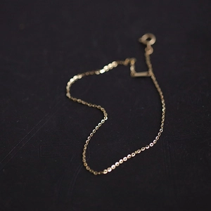 Detailed macro shot of a delicate 14k gold-plated 925 silver chain with a round clasp