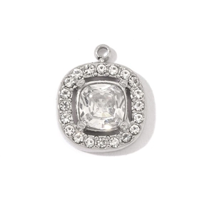 Macro view of a square silver pendant with a central faceted gem and rhinestone border