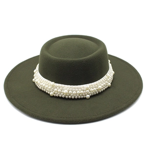 Detail of olive green wool felt boater hat featuring a decorative white pearl band