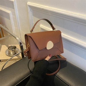 Sac à main marron chic avec boucle dorée en forme de galet et bandoulière élégante