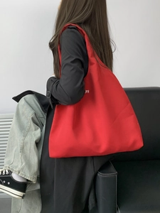 Detail of red canvas tote bag showing the durable fabric texture and letter print