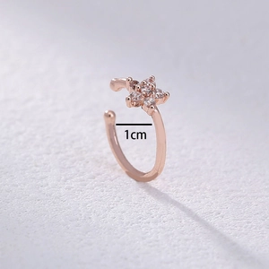 Macro view of rose gold clip-on earrings with star design and 1cm size measurement
