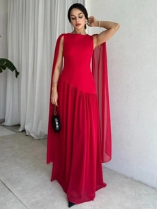 Detail of red floor-length gown featuring elegant translucent cape sleeves and waist pleats