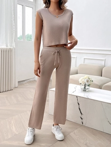 Detail of beige ribbed knit two-piece set featuring sleeveless top and wide-leg trousers