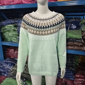 Detail of light green knit sweater with Nordic Fair Isle pattern on neckline and shoulder
