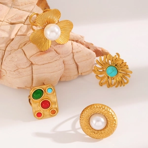Detailed close-up of retro gold rings featuring turquoise, white pearls and gemstones