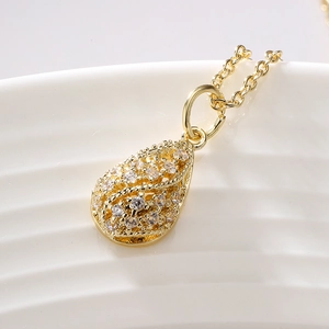 Elegant gold-plated teardrop pendant necklace with sparkling cubic zirconia on a white surface