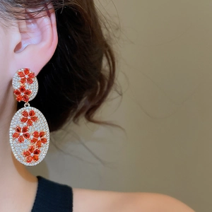 Detail of vintage oval drop earrings with red zircon flowers and white gemstone pavé