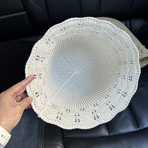 Beige hollow knit bucket hat with crochet pattern and wavy brim for sun protection