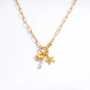 Detail of gold paperclip chain necklace with heart, starfish and pearl charms