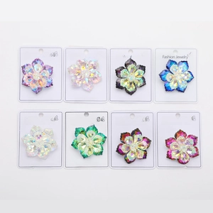 Detail view of eight multi-colored crystal flower brooches on display cards for jewelry