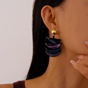 Detail of vintage layered resin earrings in deep purple and blue with gold studs
