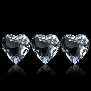 Trois pendentifs en cristal en forme de cœur avec taille facettée sur fond noir