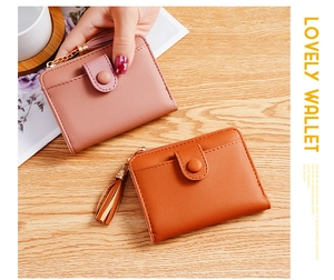 Detailed view of two compact PU leather wallets in pink and caramel with tassel zippers