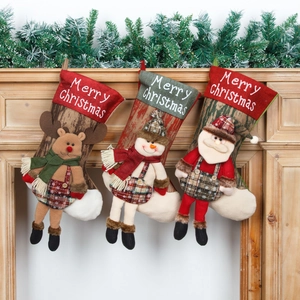 Three Christmas stockings with Santa, reindeer and snowman hanging on a wooden fireplace
