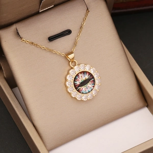 Detail eines 18K Gold-Augenanhängers mit Zirkonia-Einlage in einer Schmuckschatulle