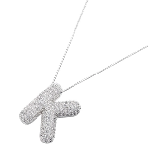 Macro view of silver color balloon letter K pendant with sparkling zircon micro-paving