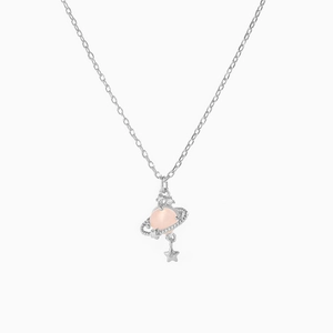 Close-up of silver planet pendant with pink stone and hanging star detail