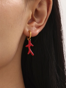 Detail of coral red drop earring in 18k gold plated steel shown on model