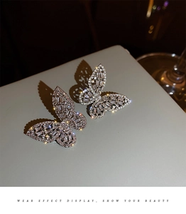 Macro shot of silver butterfly earrings with cubic zirconia inlay and refined detailing