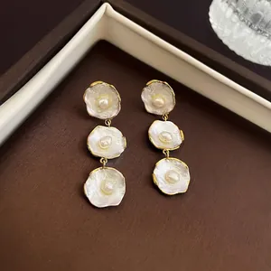 Three-tier pearl drop earrings with elegant gold trim and retro French luxury aesthetic