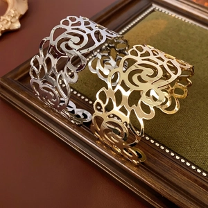 Gold and silver open cuff bracelets featuring intricate hollow floral vine patterns