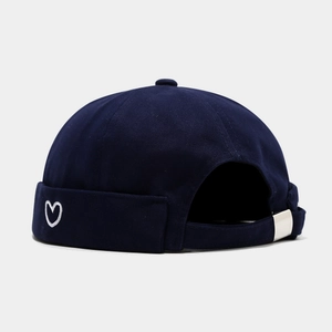 Detail view of cotton docker cap featuring heart embroidery and metal buckle strap