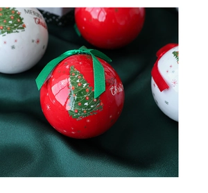 Close-up of red and white Christmas balls with Merry Christmas text on dark green satin