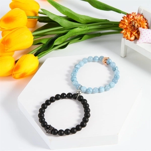 Detail of black and blue beaded couple bracelets with magnetic heart and crowns