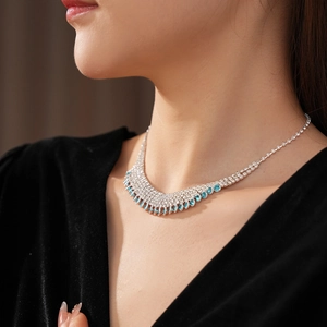 Close-up of luxury multi-row fringe necklace with silver chain and blue teardrop gems