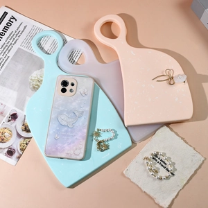 Macro shot of 3D embossed whale and shell patterns on a purple-pink gradient phone case