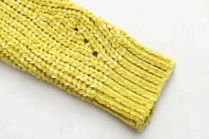 Close-up of bright yellow chenille knit fabric showing texture and ribbed cuff detail