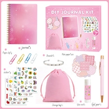 Detalle de un set de diario DIY rosa con pegatinas, bolígrafos y accesorios de libreta