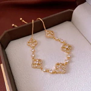 Exquisite gold clover bracelet with sparkling zircons displayed in a luxury jewelry box