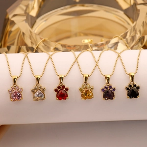Gros plan de pendentifs pattes de chat avec zircons colorés en cœur sur chaînes dorées