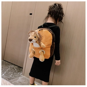 Detail of cute lion plush doll in the front pocket of a brown and orange kids backpack