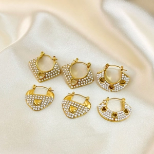 Detail of vintage 18k gold plated stainless steel earrings with pearls on silk fabric