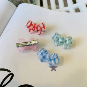 Mini checkered bow hair clips in four pastel colors with subtle glitter and duckbill clips