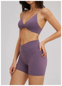 Détail du short à taille en V croisée et du soutien-gorge de sport torsadé violet