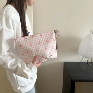 Close-up of pink checkered makeup bag with tiny bow details and Sozakka label