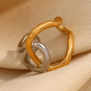 Close-up of two-tone gold and silver wavy double-layer ring on beige knit fabric