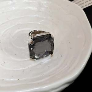 Macro shot of large square dark grey crystal with vintage silver claw setting