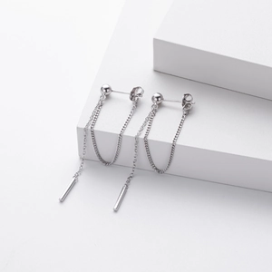 Detail of silver long chain tassel earrings with smooth cylindrical pendants on steps