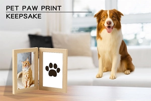 Detail of wooden pet paw print keepsake frame with photo and ink pad in a home setting