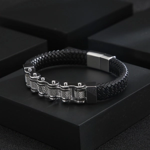 Detail of punk biker bracelet showing steel chain links and woven black leather cord