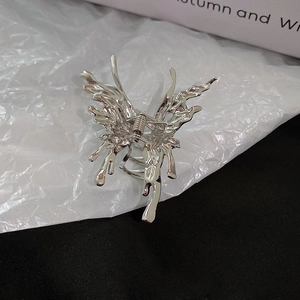 Detailed macro shot of silver liquid metal butterfly hair claw clip with metallic spring