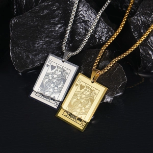 Gold and silver poker King of Hearts pendant necklaces on dark textured rock