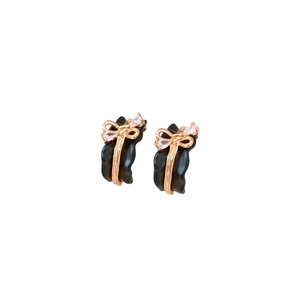 18k gold-plated C-shaped earrings featuring black wavy resin and golden bow with zircons