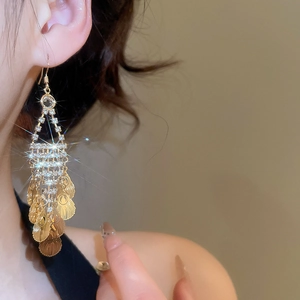 Close-up of elegant leaf tassel earrings with sparkling rhinestones in gold finish