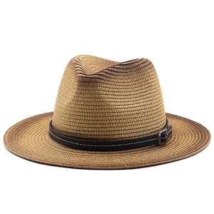 Detailed view of woven straw sun hat with black leather band and silver buckle